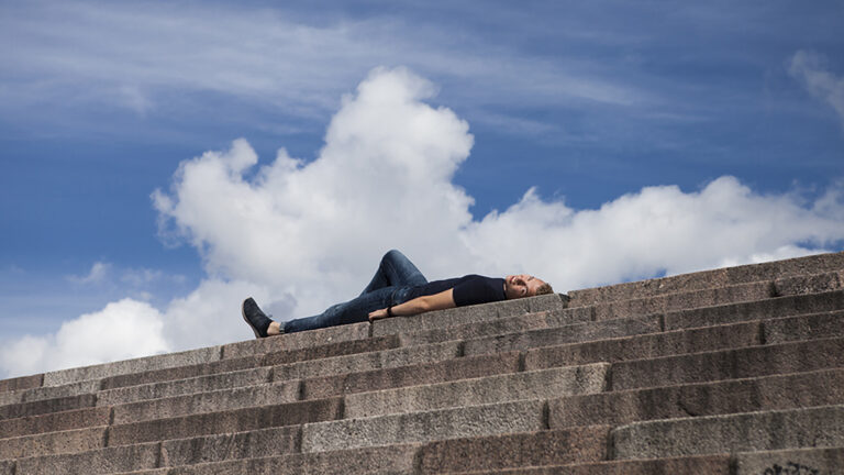 Kantasoluja luovuttanut mies makaamassa Helsingin tuomiokirkon portaiden yläpäässä.