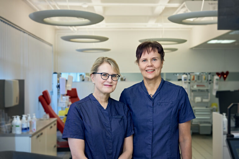 Two nurses from Blood Service smile at the camera at the blood donation site.
