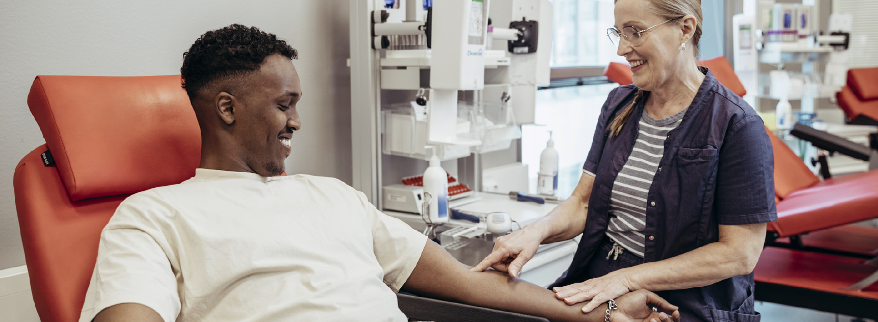 The Blood Service nurse smiles while showing the puncture site to the blood donor.