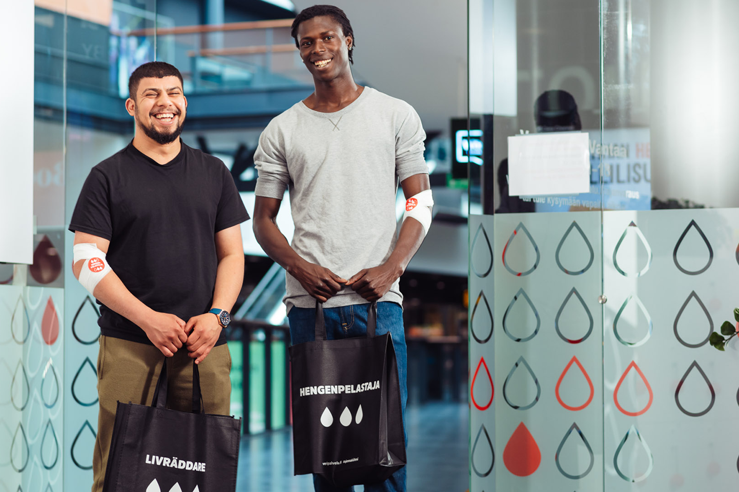 Två blodgivare med Livräddare-väskor.