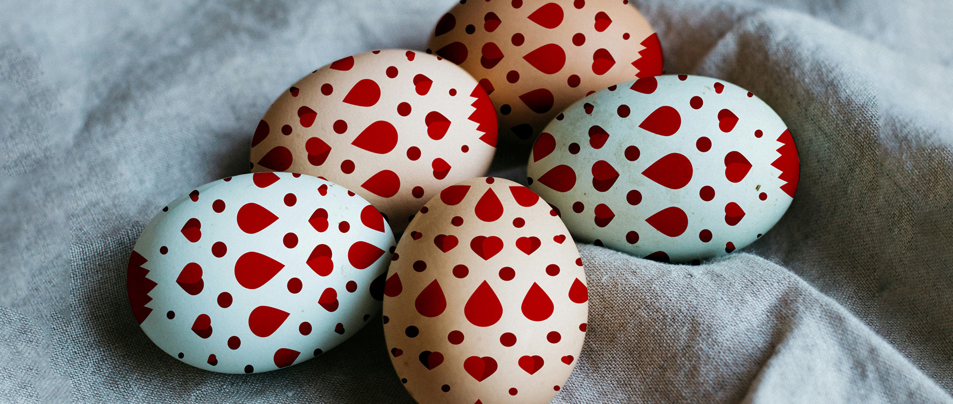 Kuvassa neljä sydämillä ja pisaroilla koristeltua pääsiäismunaa.