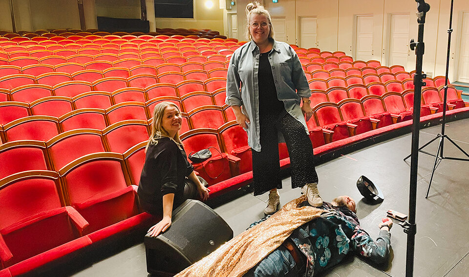 Mainostoimiston henkilökunta teatterissa kampanjakuvauksissa.