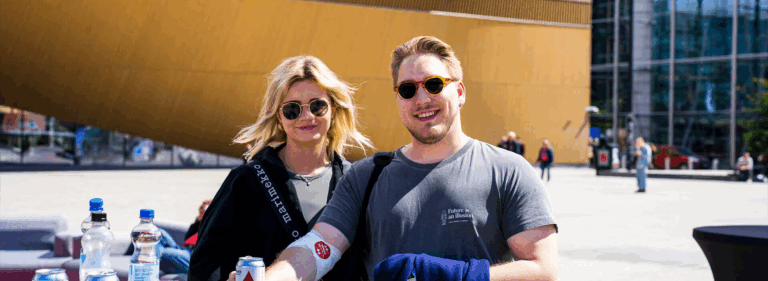 Two smiling people photographed outdoors at the Blood Service summer event on World Blood Donor Day.