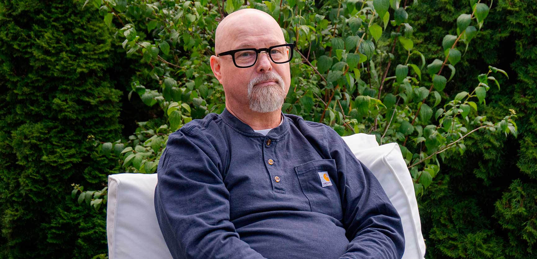 Kimmo Ståhlberg kuvattuna ulkona istumassa tuolilla.