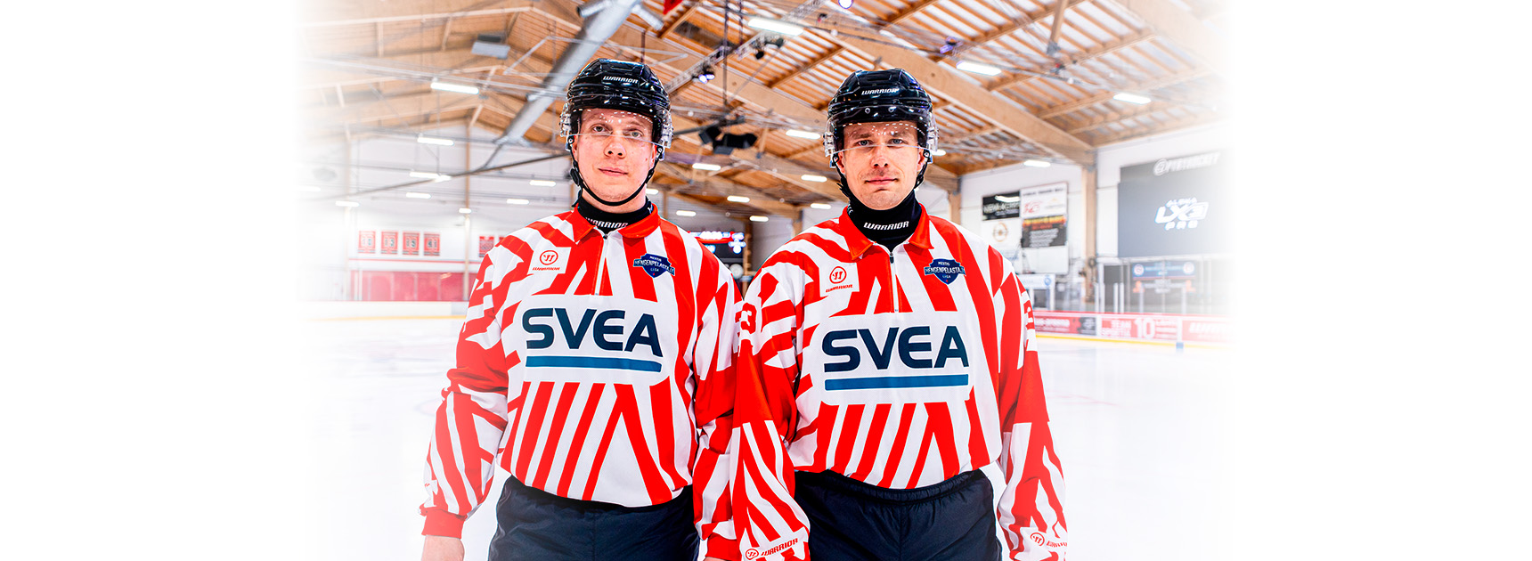 Kaksi jääkiekkotuomaria, joilla puna-valkoiset tuomaripaidat.