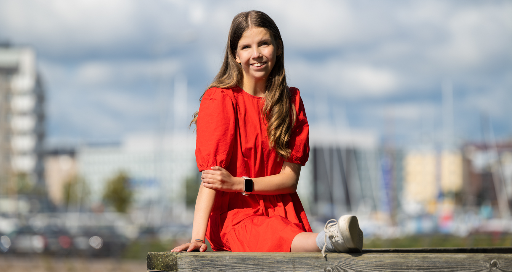 Elli Malinen istuu laiturilla.