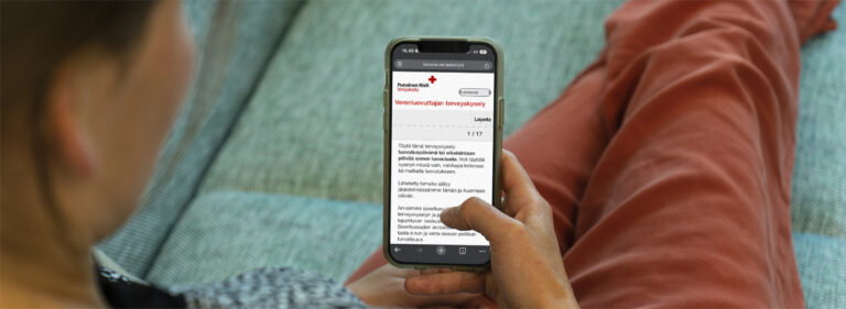 Blood donor looks at the health questionnaire on the phone.