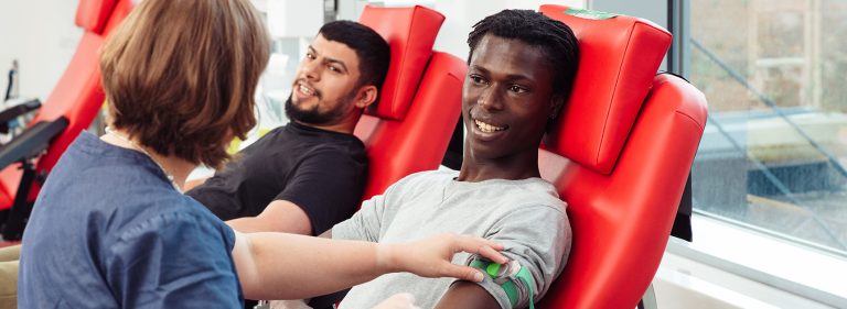 Verenluovuttajat ja hoitaja kuvattuna verenluovutuspisteellä.