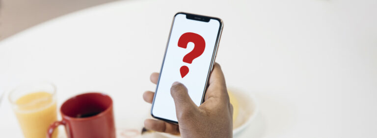 A man looking at a mobile phone with a red question mark with a drop instead of a dot.