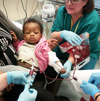 Emille in his mother's arms during exchange transfusion in hospital.