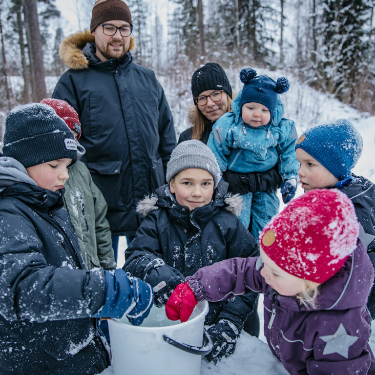 Nurmijärveläinen Hyryn perhe leikkimässä ulkona talvella.