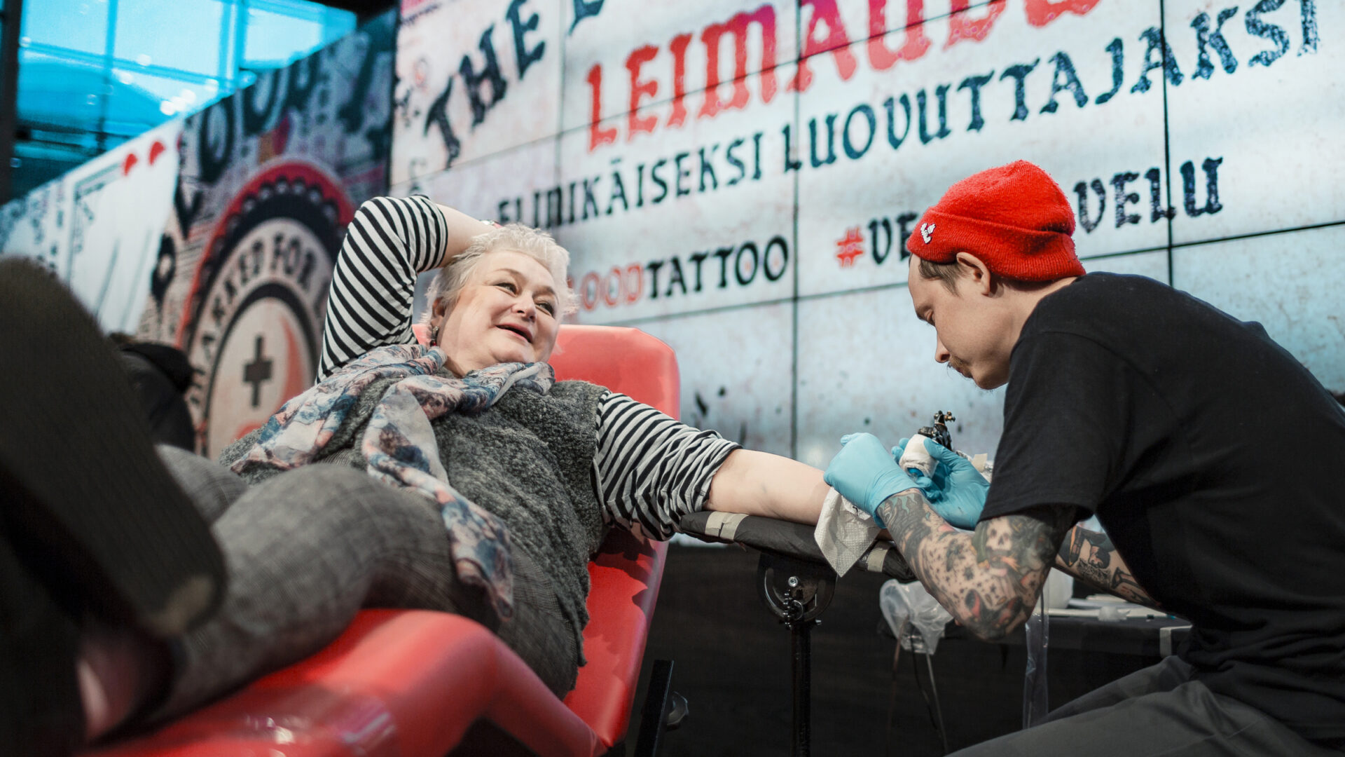 Päivi Syväsalo luovutuspedillä ottamassa tatuointia Blood Tattoo -tapahtumassa.