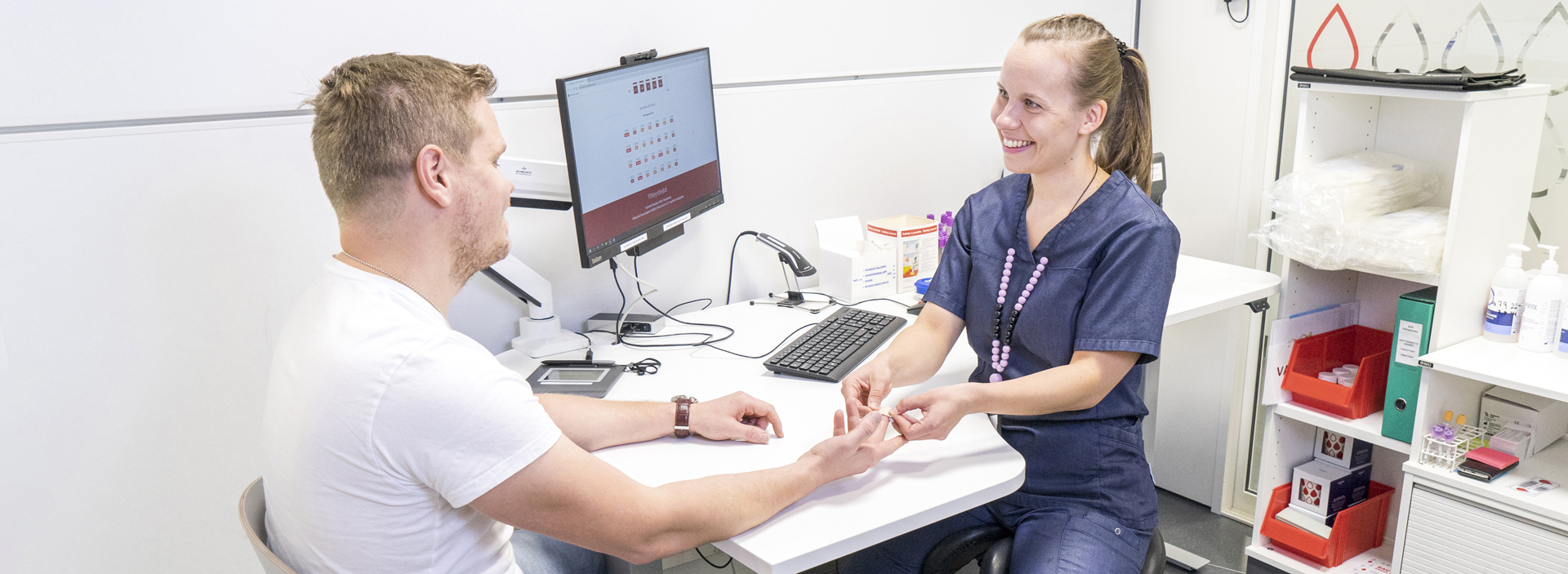 a nurse applying a patch to a blood donor after measuring hemoglobin.