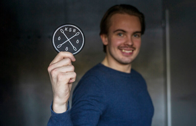 A young man showing the badge of the Stem cell registry.