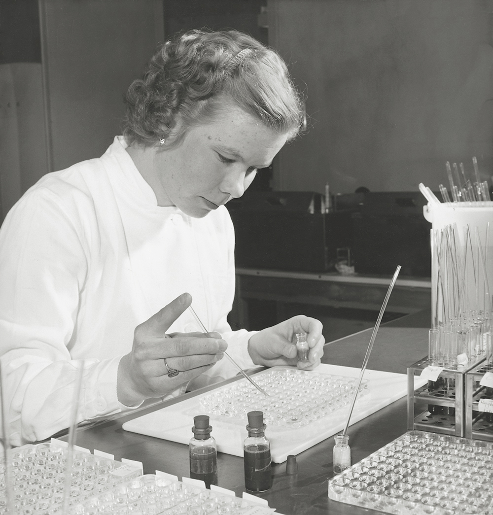 Mustavalkoinen kuva naisesta tekemässä manuaalista veriryhmämääritystä vuonna 1960.