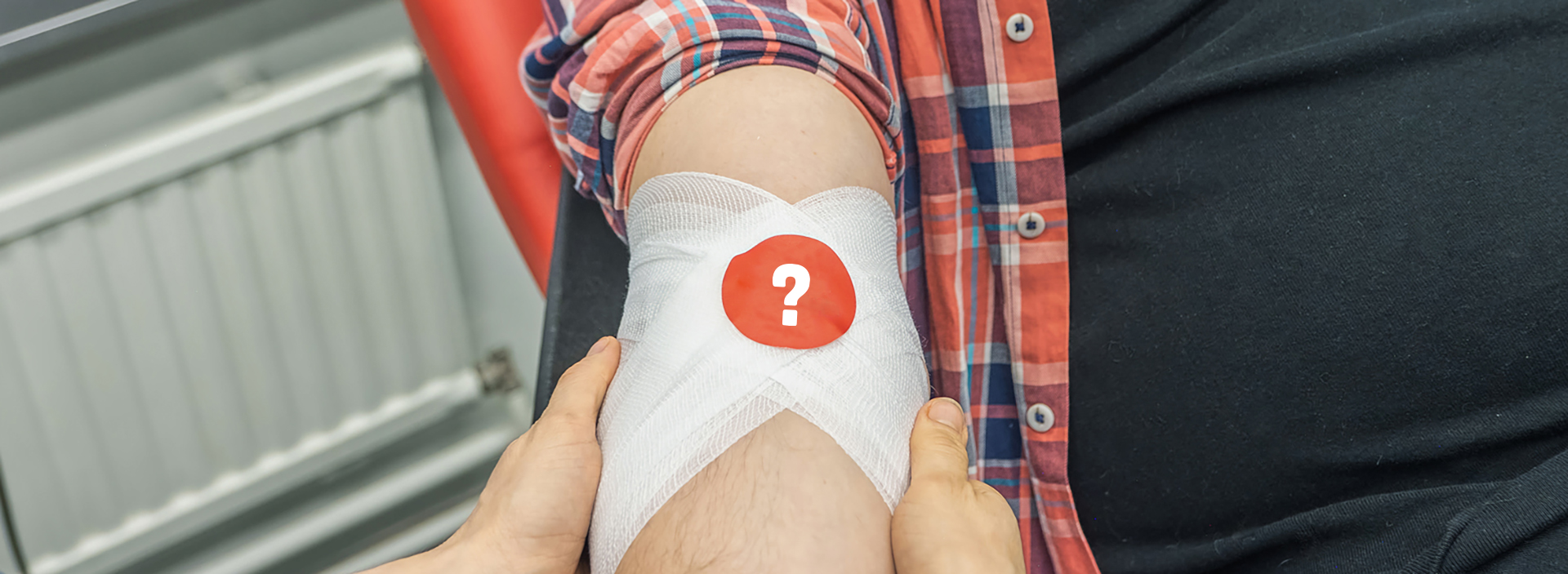 A blood donor's hand with a question mark on a bandage sticker.
