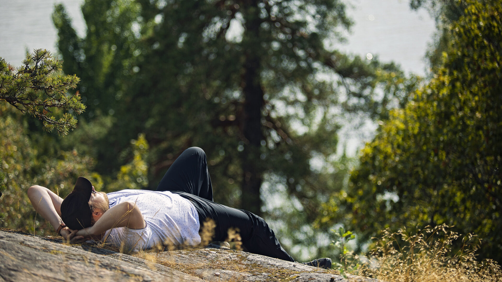 Mikko Mäkinen makaa kalliolla ja nauttii auringosta.