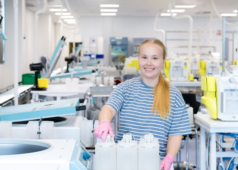 An employee of the Blood Service in blood components production, smiling at the camera.