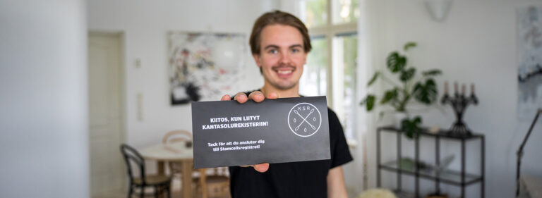 A young person holding saliva sample collection kit.