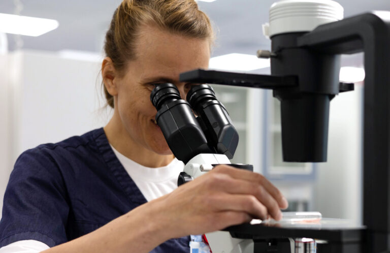 A laboratory specialist using a microscope.