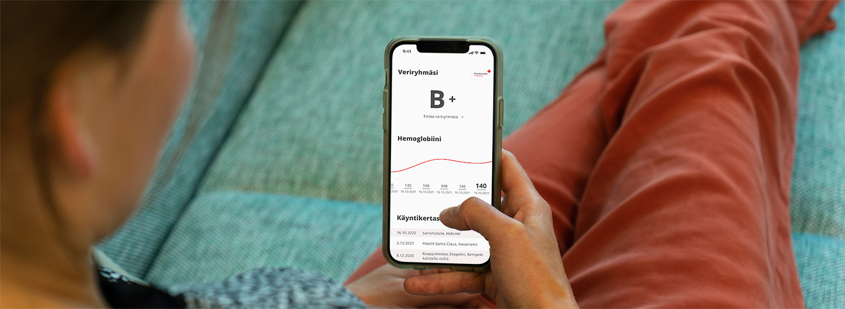 En person som använder Blodgivarappen i soffan hemma.