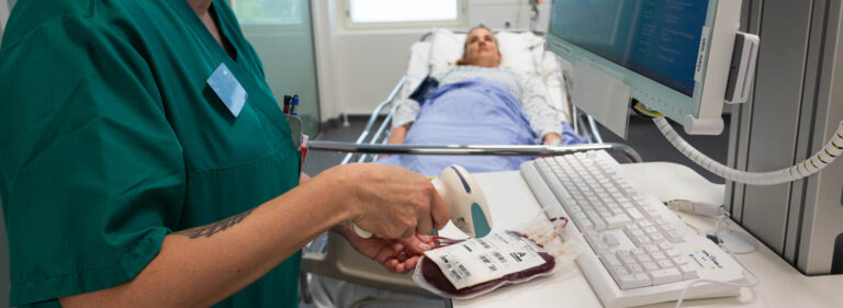 A nurse preparing a red blood cell product for transfusion.