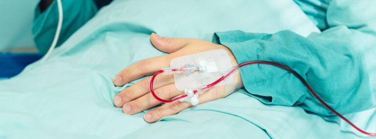 En patients hand med en kanyl för transfusion av röda blodkroppar.