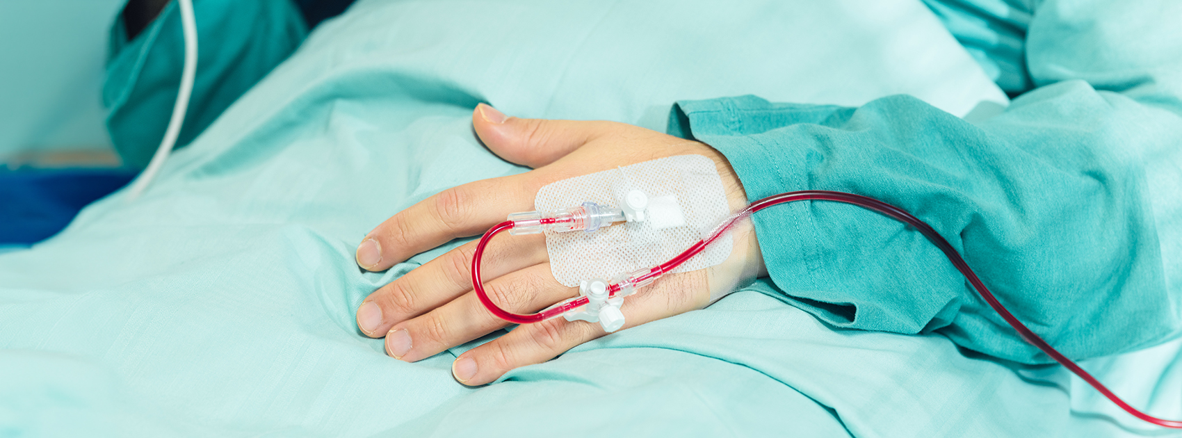 En patients hand med en kanyl för transfusion av röda blodkroppar.